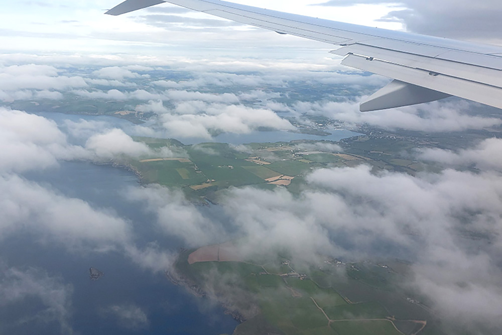 A view from the plane window of the first glimpse of green on the approach to the Emerald Isle and onto Cork from the south