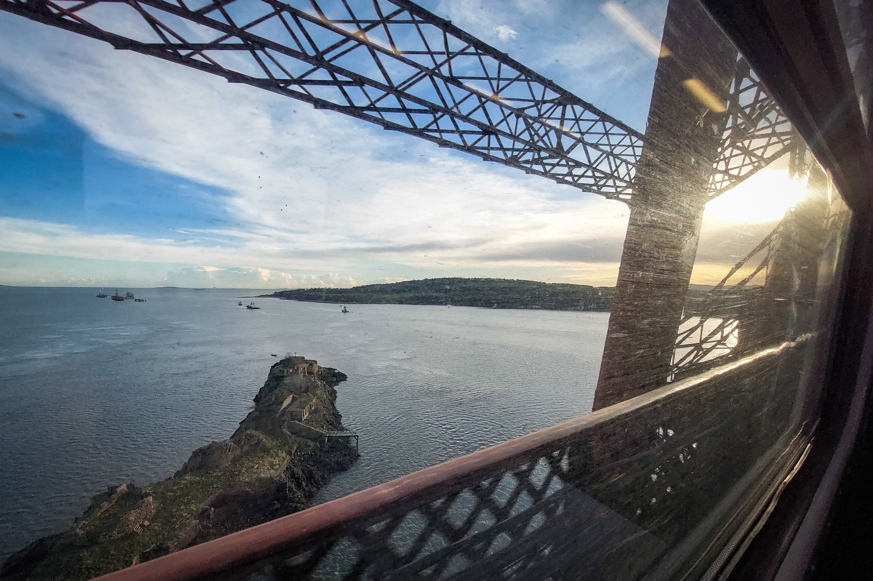 Sunrise through the Forth Bridge in transit over the firth.